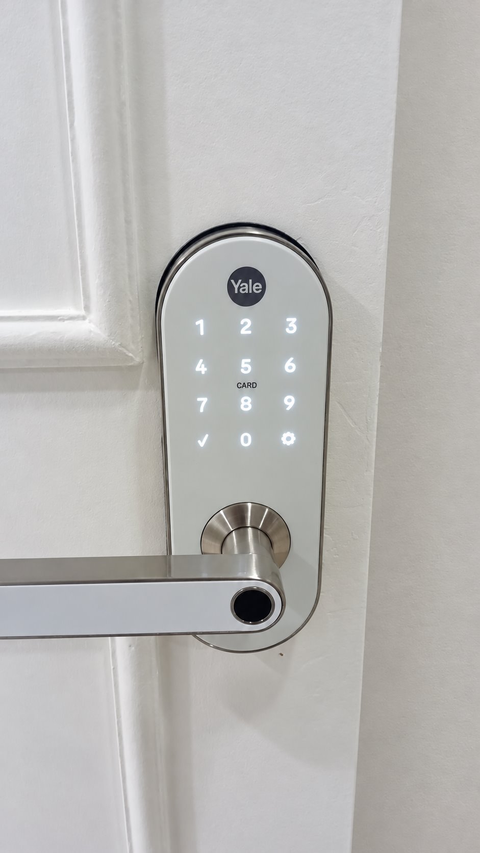 Fechadura digital Yale branca instalada em porta residencial